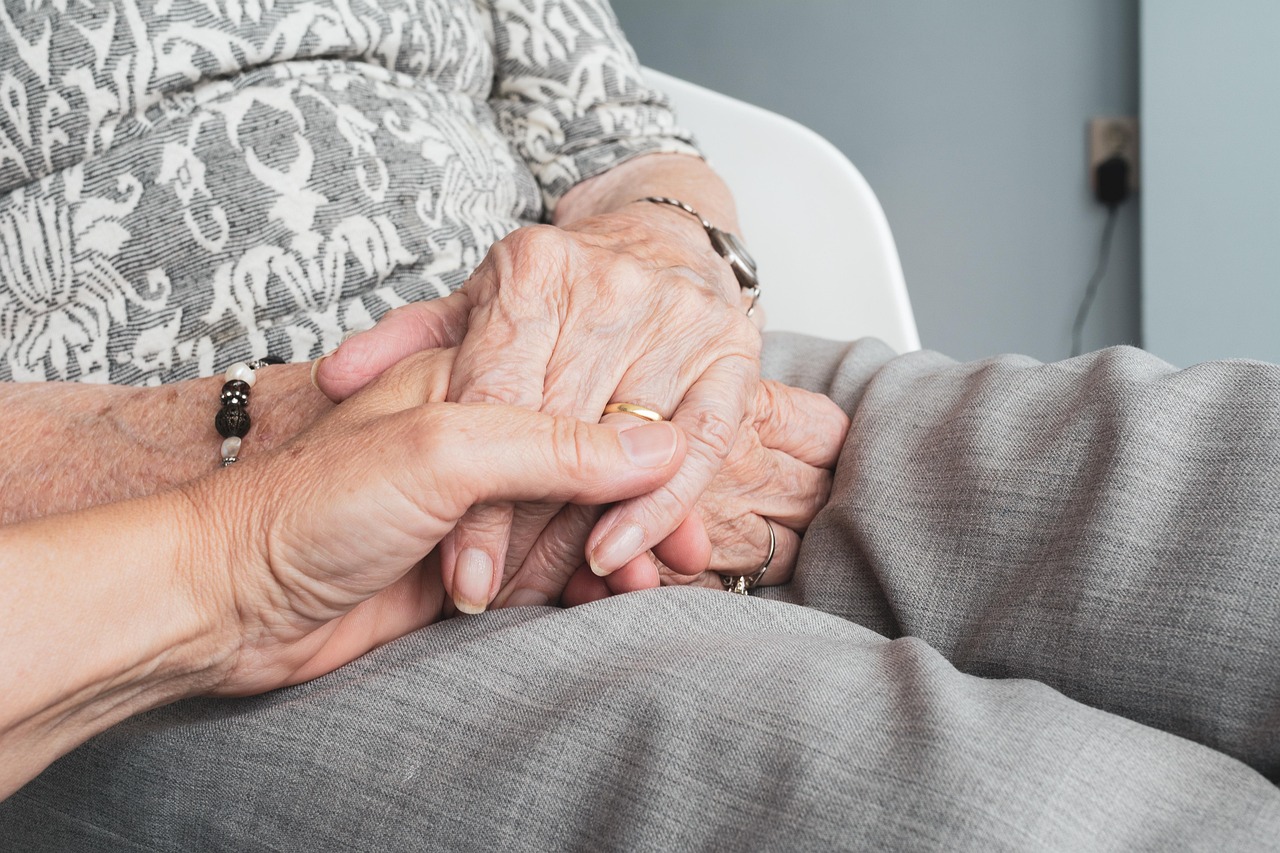 holding a senior's hands in support
