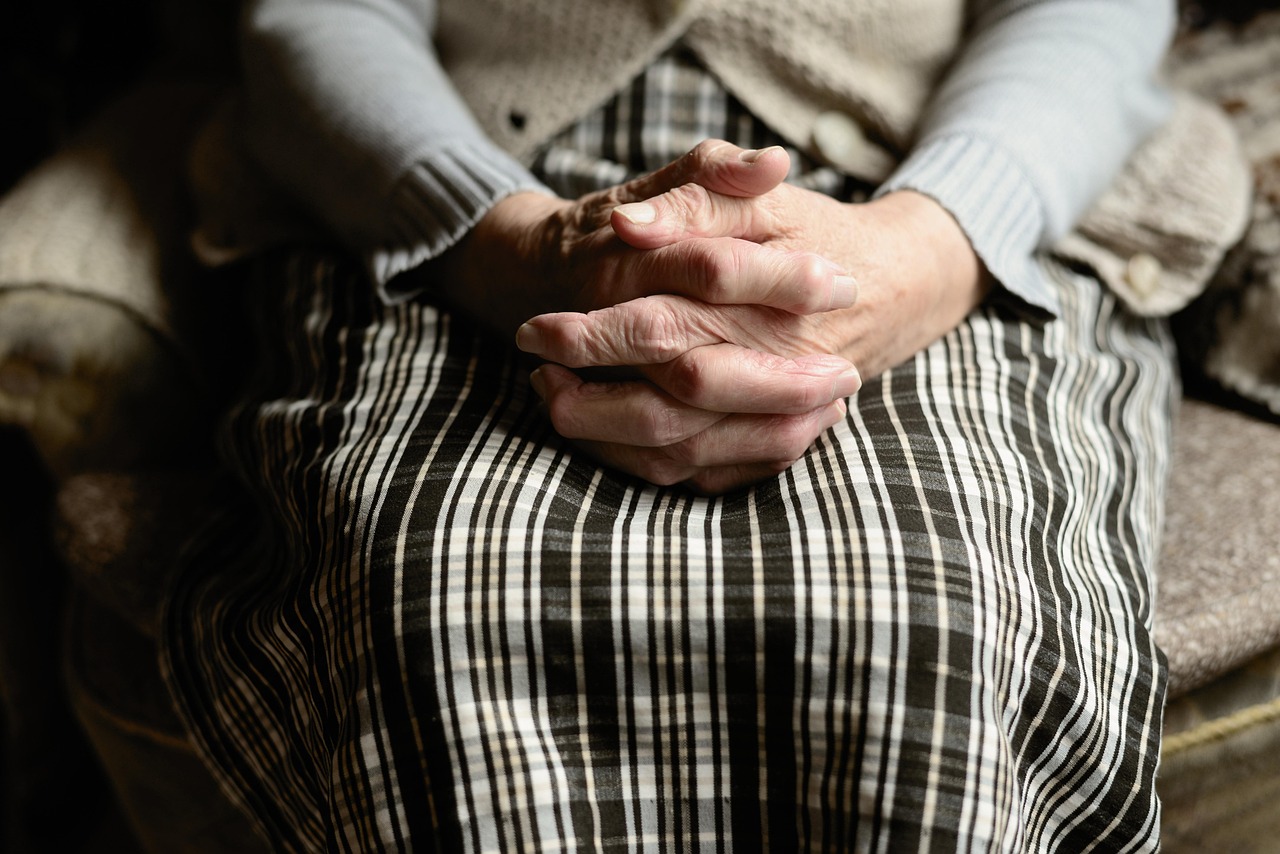 senior person holding hands with self